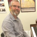 Stephen Riedel sitting at a piano